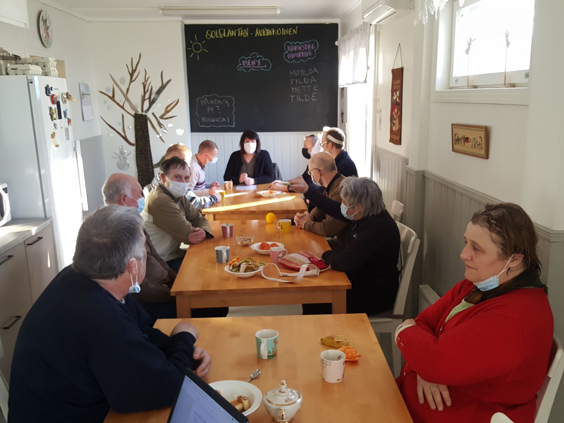 Bild på diskussionsträffen i Pargas, deltagarna sitter runt ett bord och diskuterar.
